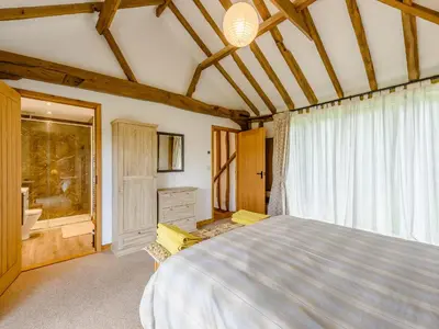a bedroom with a large bed and a window at Blackwell Barn in Raydon