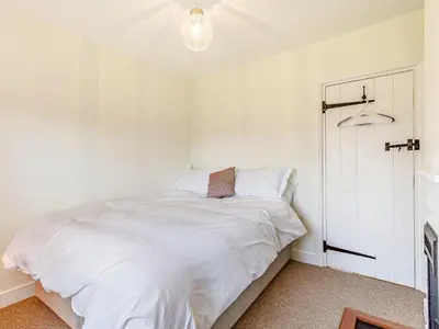 a white bedroom with a bed with white sheets at Mark Farmhouse in Bradwell on Sea