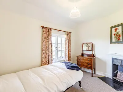 a bedroom with a bed and a window and a dresser at Mark Farmhouse in Bradwell on Sea