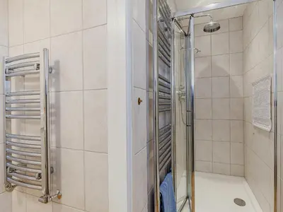 a shower with a glass door in a bathroom at Mark Farmhouse in Bradwell on Sea