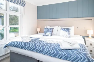 a blue and white bedroom with a large bed at Sea Breeze - Aldeburgh Coastal Cottages in Sizewell