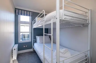 a bedroom with two bunk beds and a window at Sea Breeze - Aldeburgh Coastal Cottages in Sizewell