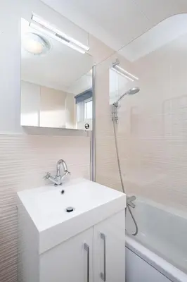 a white bathroom with a sink and a shower at Sea Breeze - Aldeburgh Coastal Cottages in Sizewell