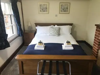 a bedroom with a large bed with two baskets on it at Little Easton Manor in Great Easton
