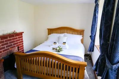a bedroom with a wooden bed with flowers on it at Little Easton Manor in Great Easton