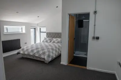 a bedroom with a bed and a sliding glass door at Toothbrush Apartments - Central Ipswich - Fore St in Ipswich
