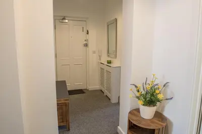 a bathroom with a sink and a vase of flowers on a table at Toothbrush Apartments - Central Ipswich - Fore St in Ipswich