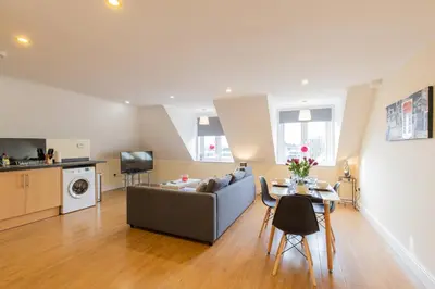 a living room with a couch and a table at 2 Bedroom Penthouse, Clockhouse, Hoddessdon in Hoddesdon