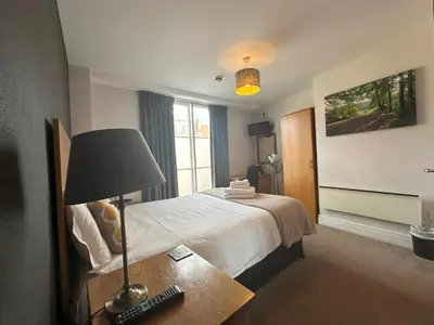 a hotel room with a bed and a lamp on a table at The North Hill Hotel, Colchester in Colchester