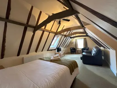 a bedroom with a large bed in a room with beams at The North Hill Hotel, Colchester in Colchester