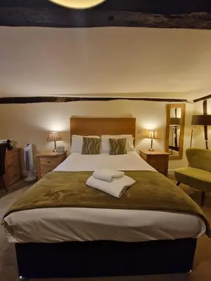a bedroom with a large bed with two tables and two lamps at The North Hill Hotel, Colchester in Colchester
