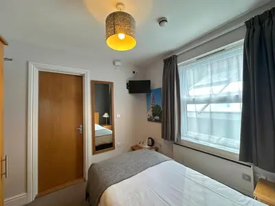 a bedroom with a bed and a window at The North Hill Hotel, Colchester in Colchester