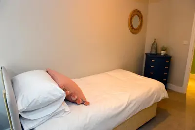 a bedroom with a bed with white sheets and pillows at 10A Ruston Chambers Free parking, Luxury 2 bedroom city center apartment in St Ives