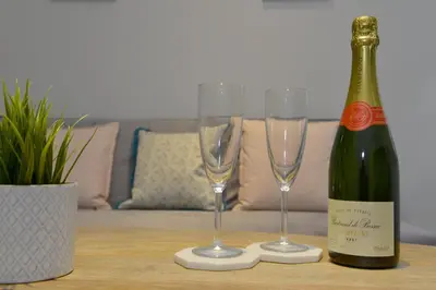 a bottle of wine and two champagne glasses on a table at 10A Ruston Chambers Free parking, Luxury 2 bedroom city center apartment in St Ives