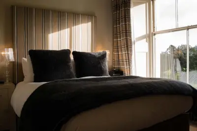 a bedroom with a large bed with a window at Milsoms Kesgrave Hall in Ipswich
