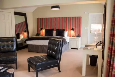 a bedroom with a bed with a chair and a desk at Milsoms Kesgrave Hall in Ipswich
