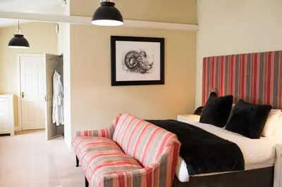 a bedroom with a bed and a couch at Milsoms Kesgrave Hall in Ipswich