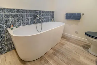 a white bath tub in a bathroom with a toilet at 2 Bed in Snape oc-sfvin in Snape