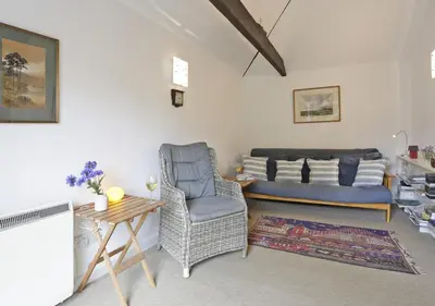 a living room with a couch and a chair at High Tide in Aldeburgh