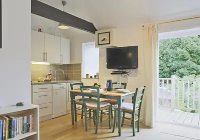 a kitchen with a table and chairs and a television at High Tide in Aldeburgh