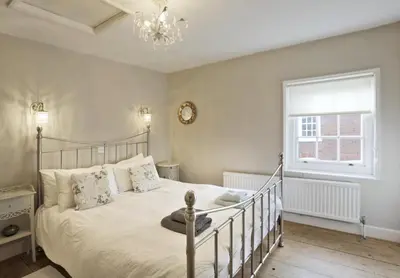 a bedroom with a bed and a window and a chandelier at 1 Bed in Woodbridge oc-jsm in Woodbridge