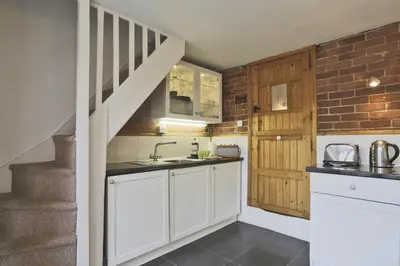 a kitchen with white cabinets and a staircase at 1 Bed in Woodbridge oc-jsm in Woodbridge