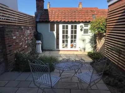 a patio with two chairs and a table in front of a house at 1 Bed in Woodbridge oc-jsm in Woodbridge