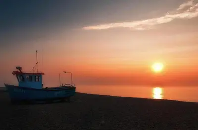a boat sitting on the beach at sunset at 1 Bed in Aldeburgh oc-sld in Aldeburgh