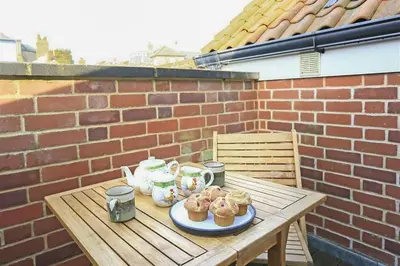 a wooden table with a plate of donuts on it at 1 Bed in Aldeburgh oc-sld in Aldeburgh
