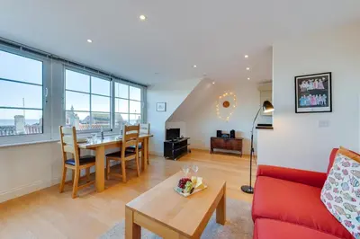 a living room with a red couch and a table at 1 Bed in Aldeburgh oc-sld in Aldeburgh