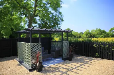 a gazebo with a bench and two plants at 1 Bed in Sibton oc-sfbor in Sibton