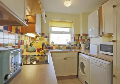 a kitchen with a washer and dryer in it at 2 Coastguard Court in Aldeburgh