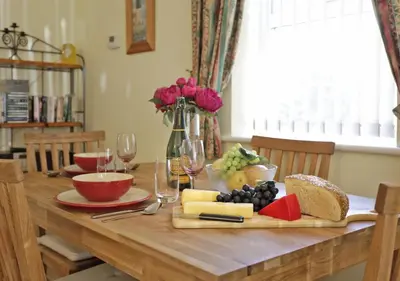 a wooden table with cheese and other foods on it at 2 Coastguard Court in Aldeburgh