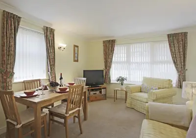a living room with a table and a television at 2 Coastguard Court in Aldeburgh