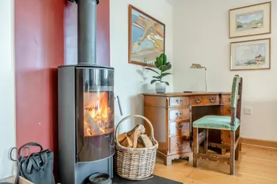 a fireplace in a room with a desk and a chair at 1 Bed in Woodbridge oc-meb in Sudbourne
