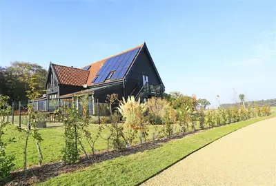 a black house with a row of trees in front of it at 1 Bed in Woodbridge oc-meb in Sudbourne
