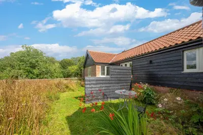 a house with a garden next to a building at 1 Bed in Middleton oc-stbc in Middleton