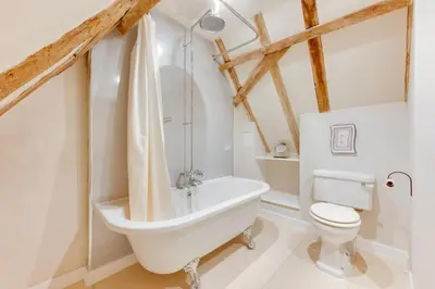 a bathroom with a white tub and a toilet at 1 Bed in Ipswich oc-spha in Harkstead