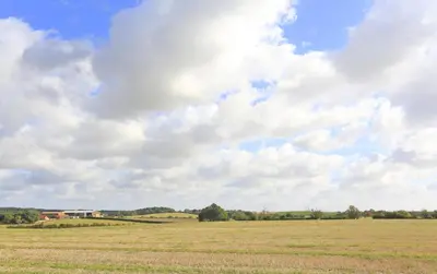 a large open field with a cloudy sky at 1 Bed in Ipswich oc-spha in Harkstead