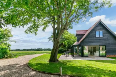 a house with a tree in front of it at 1 Bed in Sudbourne oc-tgs in Sudbourne