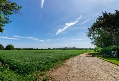 a dirt road in the middle of a green field at 1 Bed in Sudbourne oc-tgs in Sudbourne