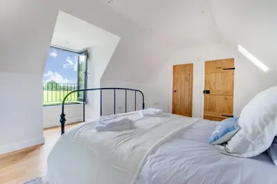 a white bedroom with a large bed and a window at 1 Bed in Sudbourne oc-tgs in Sudbourne