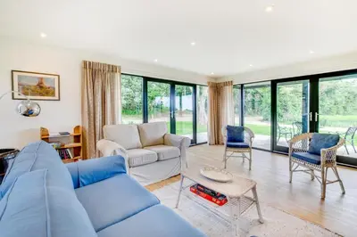 a living room with a blue couch and chairs at 1 Bed in Sudbourne oc-tgs in Sudbourne