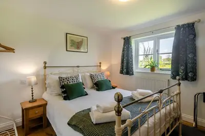 a bedroom with a large bed with green pillows at 1 Bed in Great Bealings oc-sfgar in Bealings