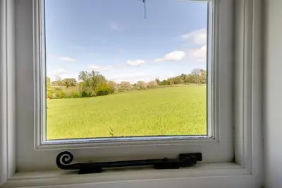 a window with a view of a green field at 1 Bed in Great Bealings oc-sfgar in Bealings