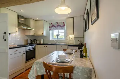 a kitchen with a table with two chairs and a sink at 1 Bed in Great Bealings oc-sfgar in Bealings