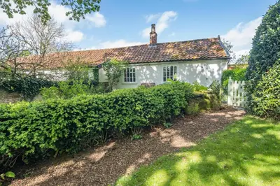 a white house with a hedge in front of it at 1 Bed in Great Bealings oc-sfgar in Bealings