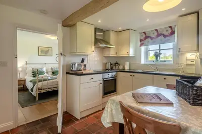 a kitchen with white cabinets and a table and a bed at 1 Bed in Great Bealings oc-sfgar in Bealings