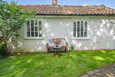 a white house with a bench in the yard at 1 Bed in Great Bealings oc-sfgar in Bealings