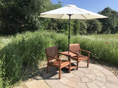a table and two chairs under an umbrella at 1 Bed in Woodbridge oc-stabu in Ufford